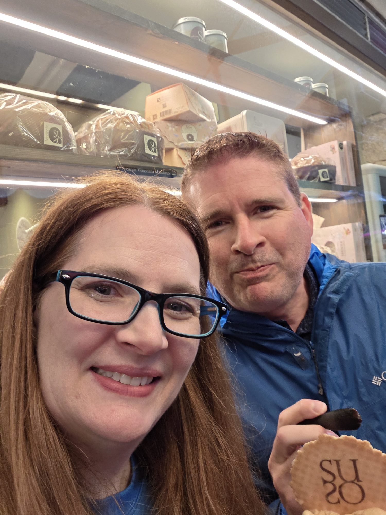Kyle and Mandy inside Gelatoteca Suso in Venice, Kyle holding a Suso wafer toward the camera